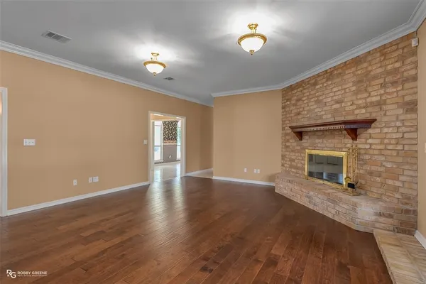 a view of a livingroom with wooden floor and a fireplace