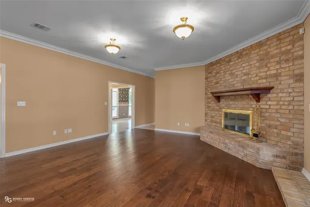 a view of a livingroom with wooden floor and a fireplace