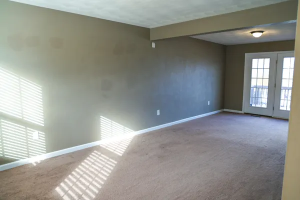 an empty room with a window and a ceiling fan
