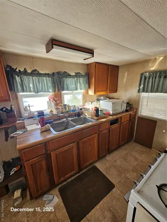 a kitchen with a sink a stove a refrigerator and cabinets