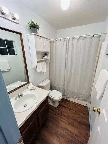 a bathroom with a sink a toilet a mirror and shower