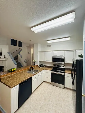 a kitchen with a sink stove and refrigerator
