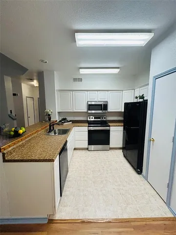 a kitchen with granite countertop a refrigerator and a sink
