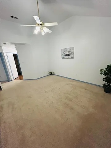 an empty room with fan and window