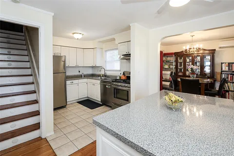 a kitchen with stainless steel appliances granite countertop a stove a sink and a refrigerator