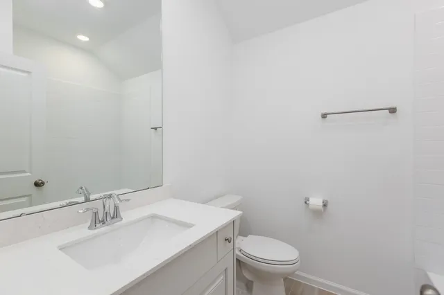 a bathroom with a sink toilet and a mirror