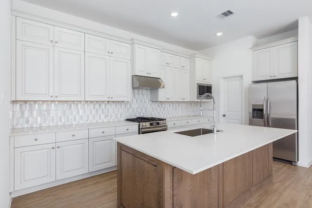 a kitchen with a white cabinets stove and refrigerator
