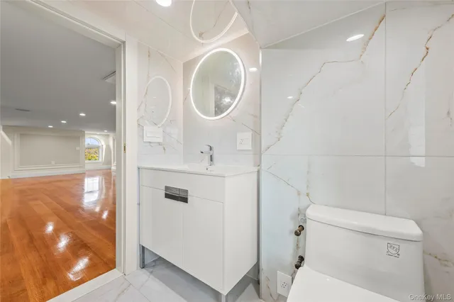 a bathroom with a sink a toilet and a mirror