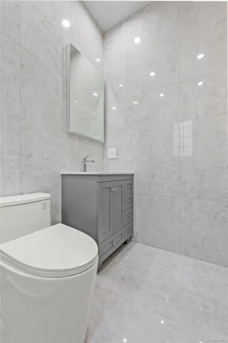 a bathroom with a toilet a sink and mirror