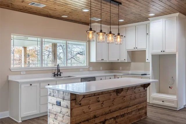 a kitchen with stainless steel appliances granite countertop a sink a stove and a window