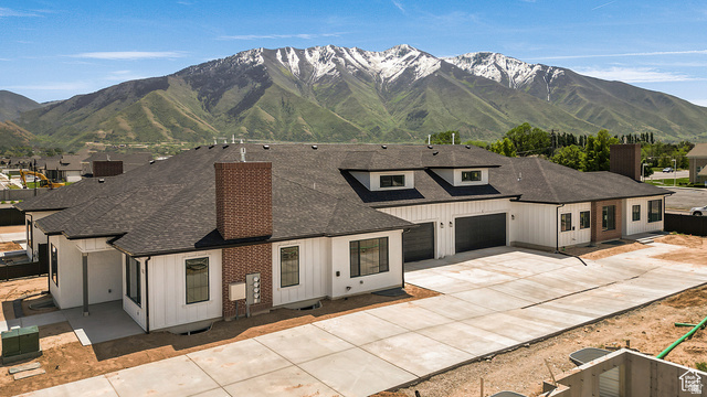 1631 West Century Lane, Unit C Mapleton, UT 84664 - Photo 30 of 31 Newly constructed residence featuring a white vertical siding exterior with dark trim accents, a dark shingle roof, and brick chimney structures