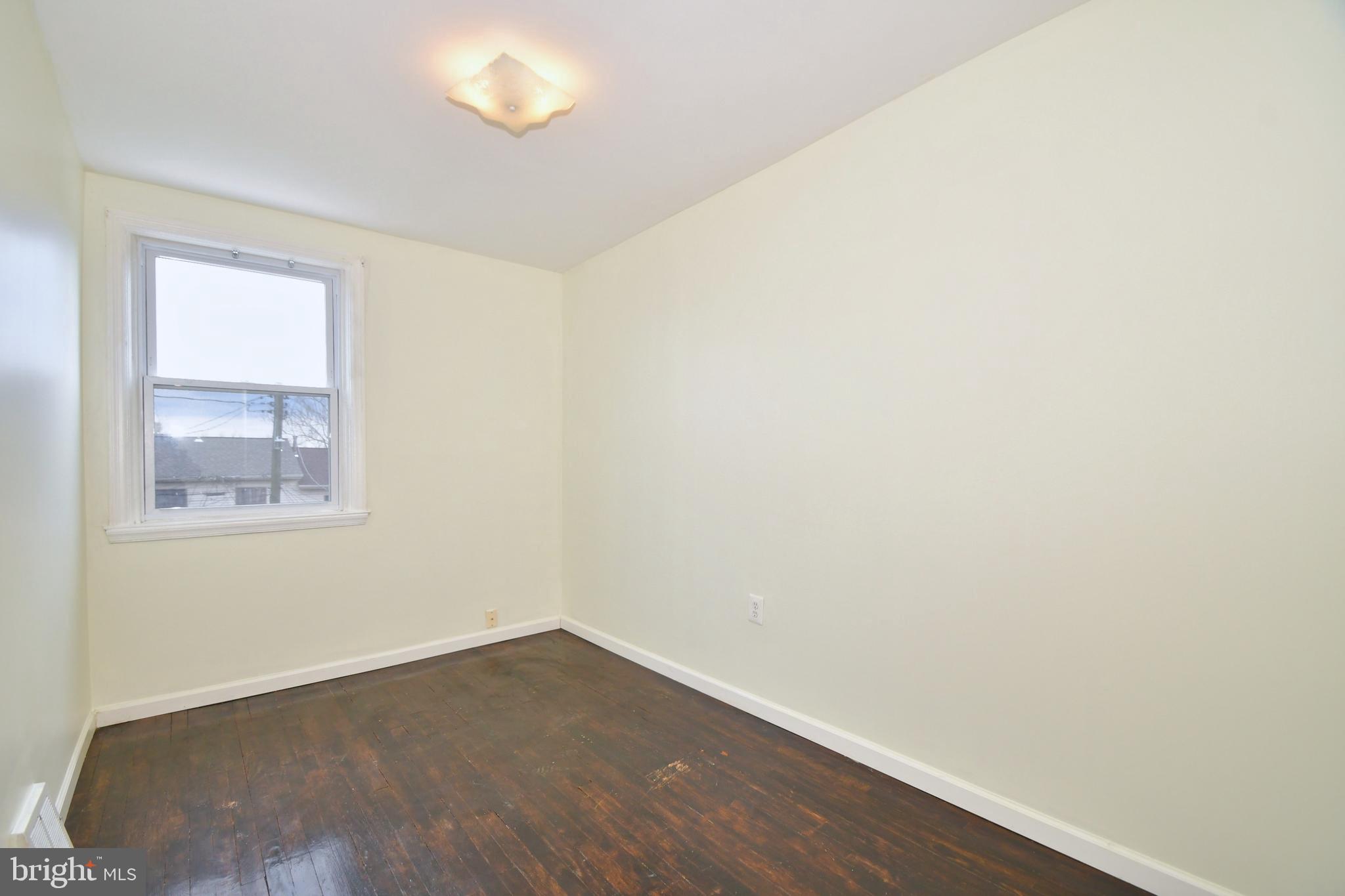731 Roundview Road Baltimore, MD 21225 - Photo 20 of 40 a view of an empty room with wooden floor and a window