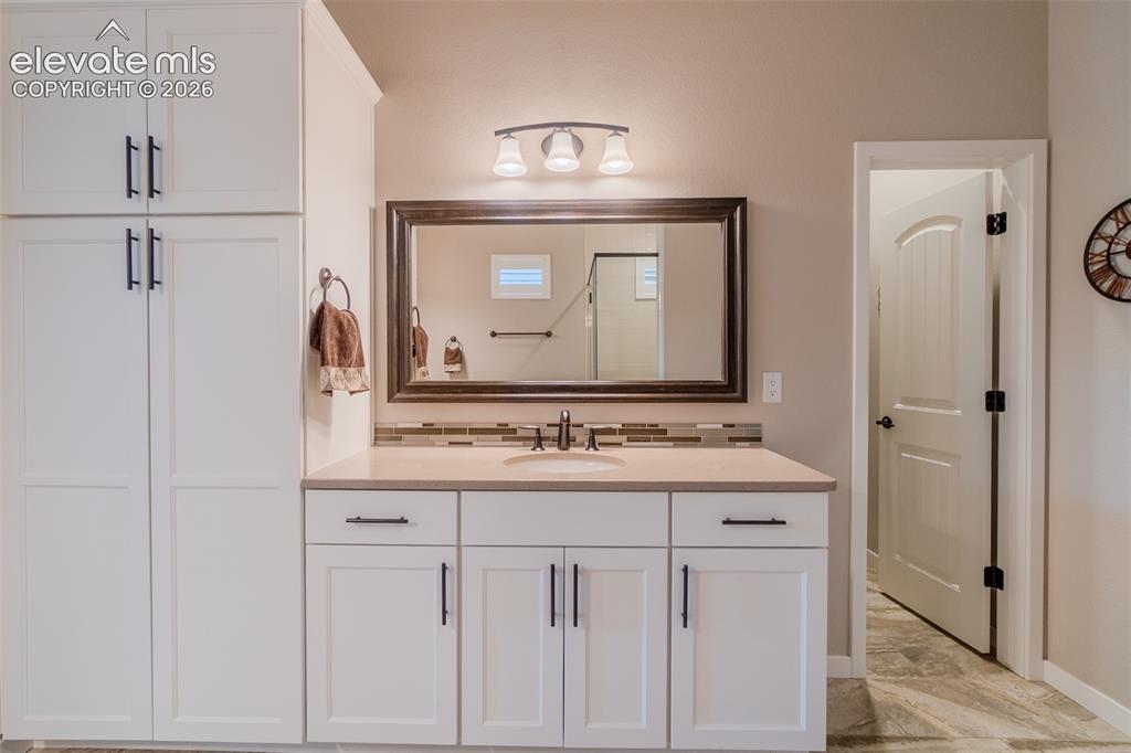 1061 Native Dancer Terrace Colorado Springs, CO 80921 - Photo 25 of 50 Bathroom featuring a single vanity with light-colored countertop, integrated sink, and dark-finish faucet