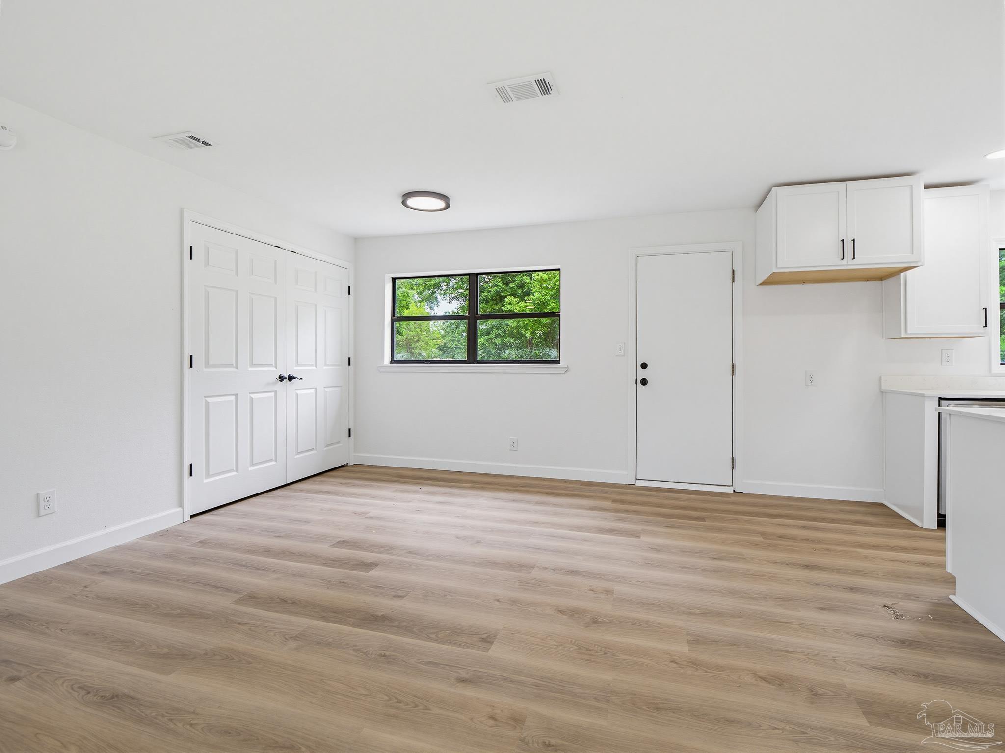 125 Madrid Road Cantonment, FL 32533 - Photo 5 of 16 a view of an empty room with wooden floor and a window