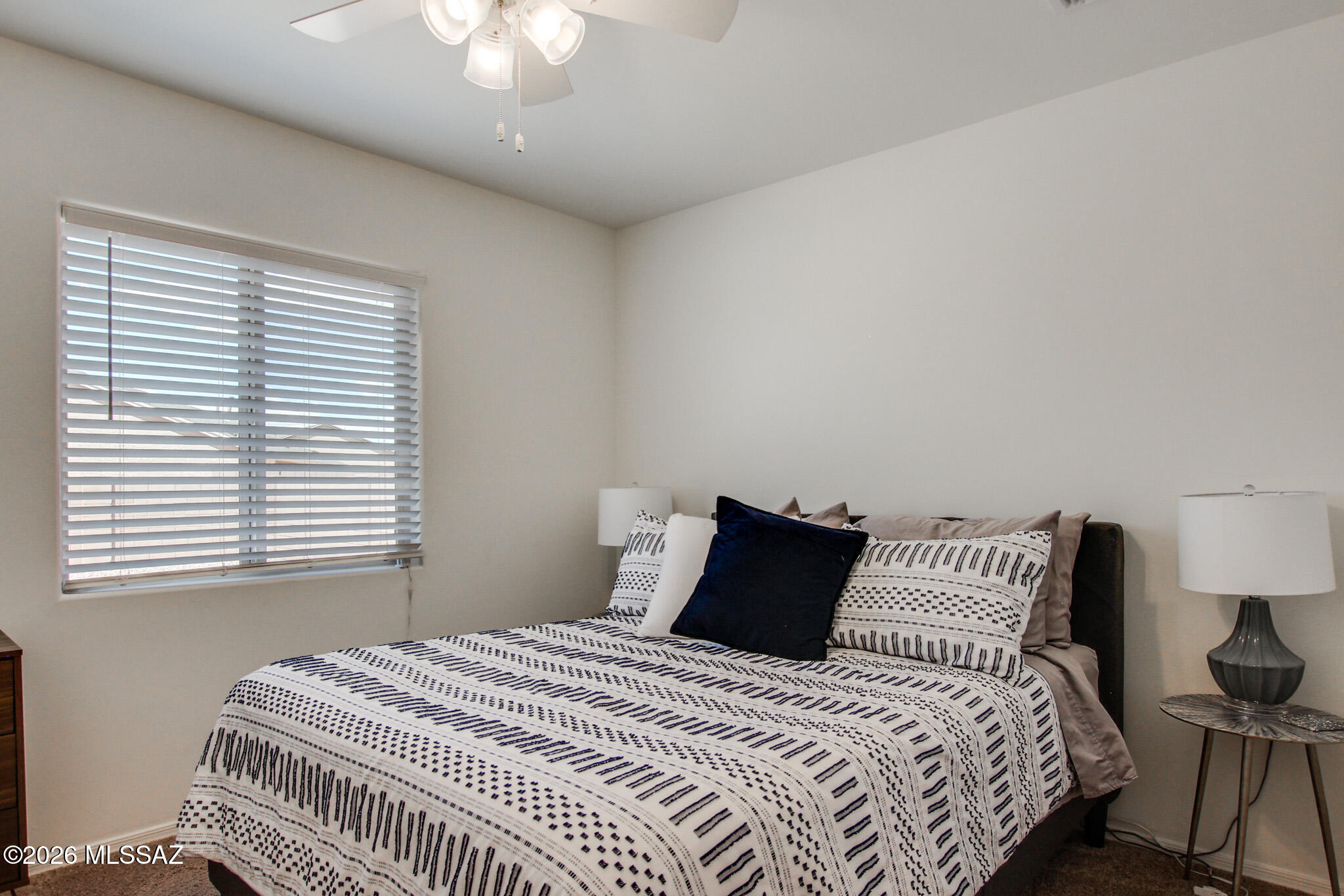 7056 South Draper Road Tucson, AZ 85757 - Photo 12 of 22 a bedroom with a bed and a chandelier