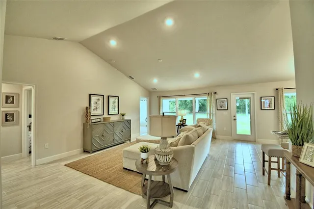 a living room with furniture and a wooden floor