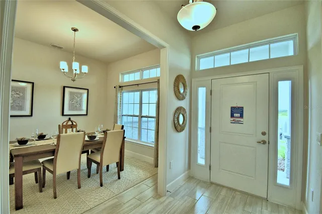 a view of a dining room with furniture and chandelier fan