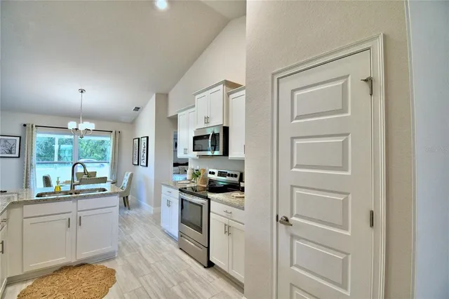 a kitchen with white cabinets and appliances