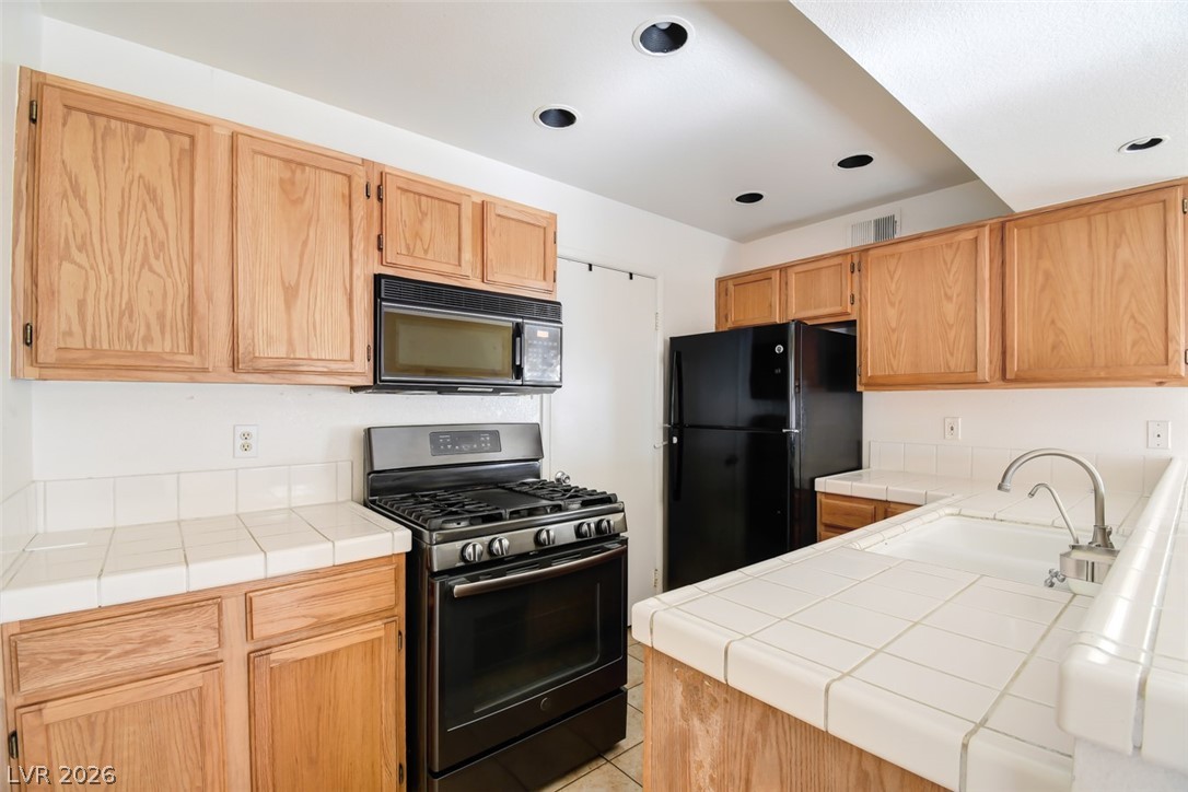 7570 West Flamingo Road, Unit 119 Las Vegas, NV 89147 - Photo 6 of 15 A functional kitchen boasts recessed lighting and essential appliances.