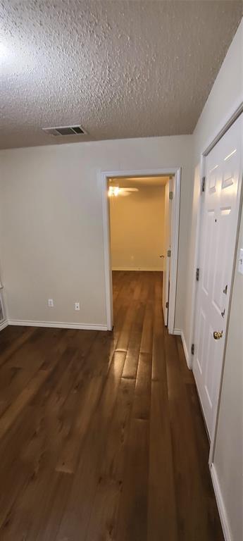 1907 Robbins Place, Unit 204 Austin, TX 78705 - Photo 4 of 7 Corridor featuring dark wood-style flooring and a textured ceiling