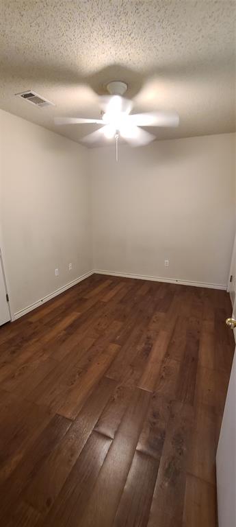 1907 Robbins Place, Unit 204 Austin, TX 78705 - Photo 6 of 7 Unfurnished room featuring dark wood finished floors, a textured ceiling, and a ceiling fan
