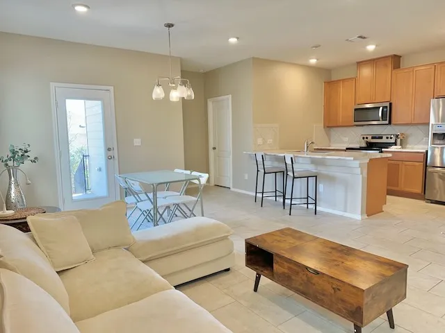 a living room with furniture kitchen and a chandelier