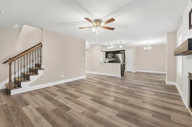 a view of a livingroom with a ceiling fan and hardwood floor