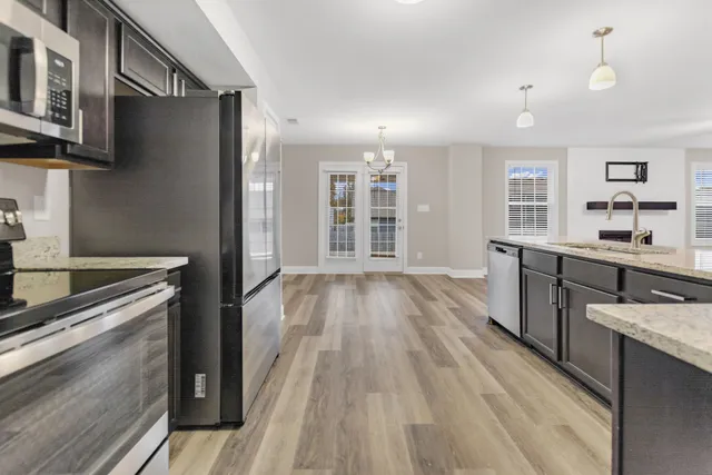 a kitchen with a sink and wooden floor