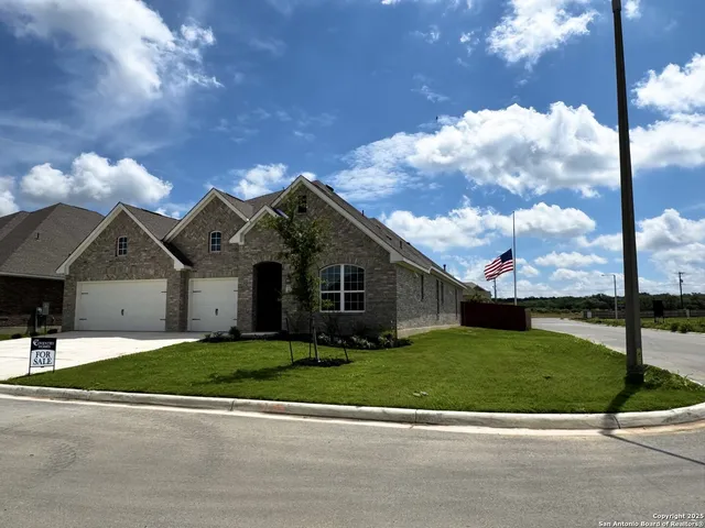 a front view of a house with a garden and yard