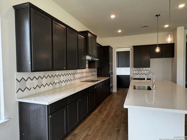 a kitchen with stainless steel appliances a sink stove and cabinets