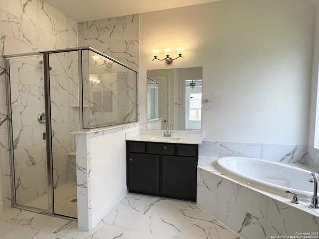 a bathroom with a bathtub sink vanity and a mirror