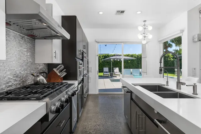 a kitchen with stainless steel appliances a stove a sink a microwave and a refrigerator