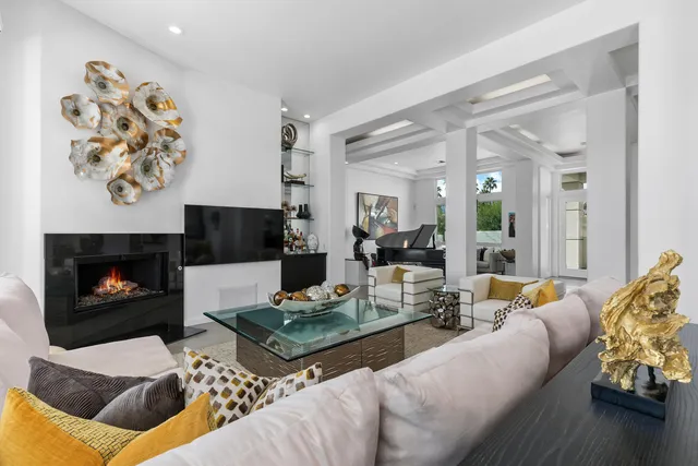 a living room with furniture fireplace and a large window