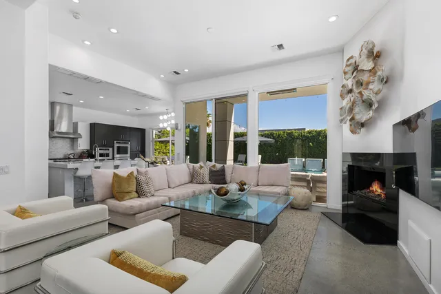 a living room with furniture fireplace and a large window