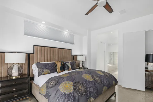 a spacious bedroom with a bed and a flat screen tv