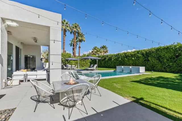 a view of a house with swimming pool and sitting area