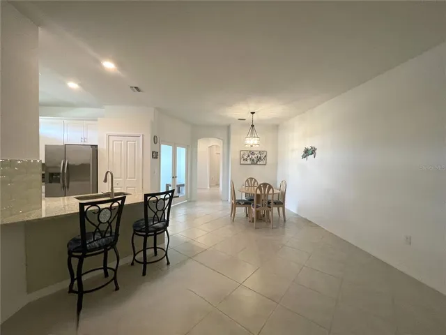 a bathroom with a granite countertop bathtub shower sink vanity and toilet