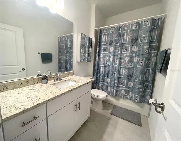 a view of a sign in a yard with potted plants and big trees