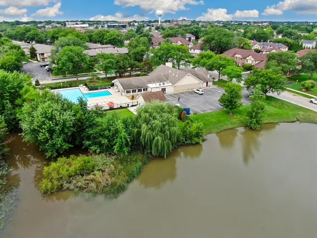 an aerial view of lake residential house with outdoor space and trees all around