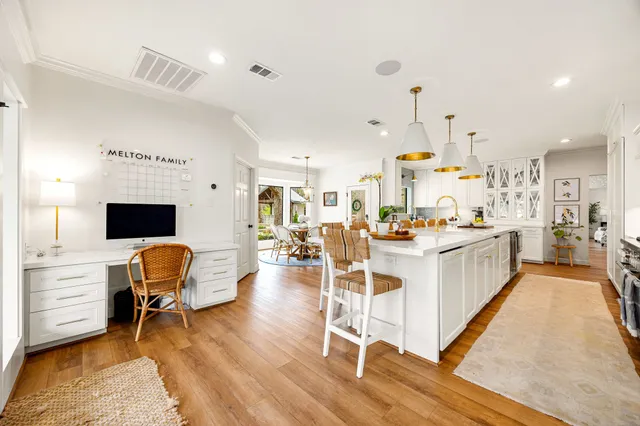 a kitchen with stainless steel appliances kitchen island granite countertop a table chairs sink and cabinets