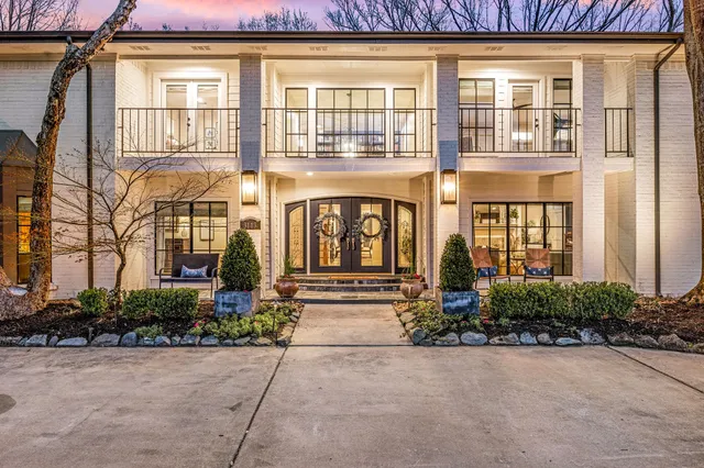 a front view of a brick house with a yard