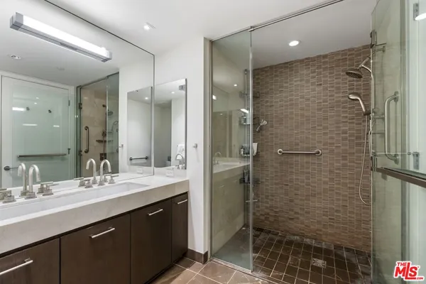a bathroom with a double vanity sink mirror and shower