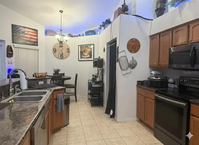 a kitchen with stainless steel appliances granite countertop a sink and a stove