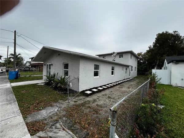 a view of a house with backyard and trees