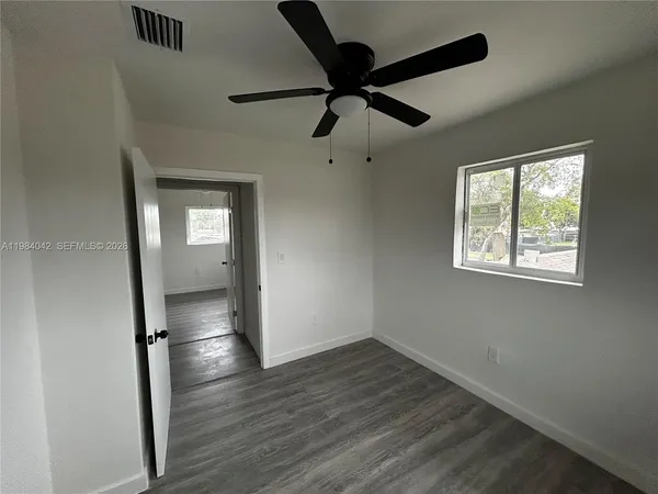 a kitchen with granite countertop white cabinets and refrigerator