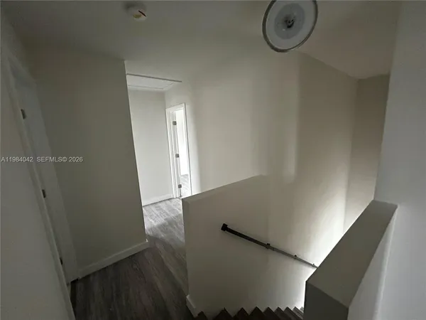 a kitchen with granite countertop white cabinets and black appliances