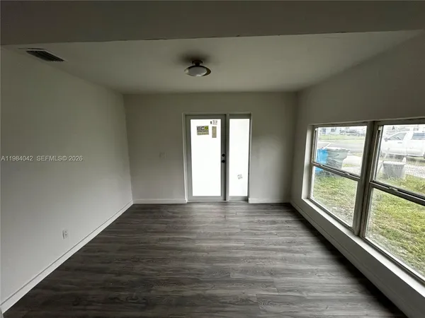 wooden floor in an empty room with a window