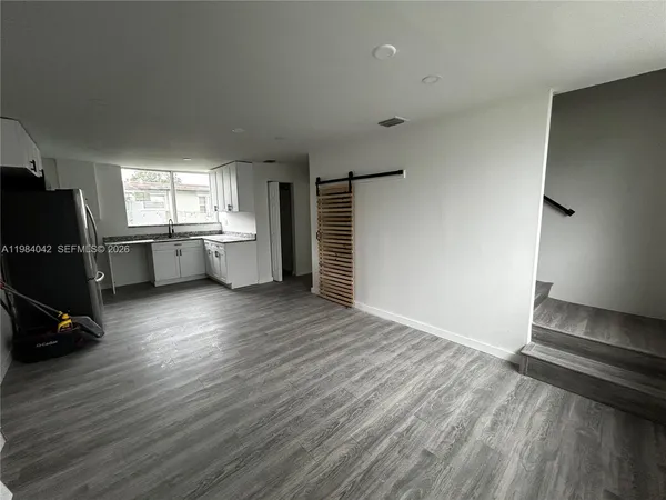 a view of a room with wooden floor and windows