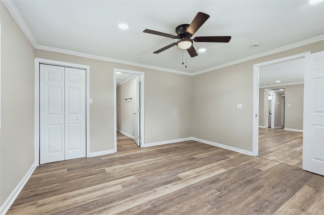 418 Old River Road Pelzer, SC 29669 - Photo 10 of 32 Gleaming wood-look floors pair with crown molding in a versatile living space.