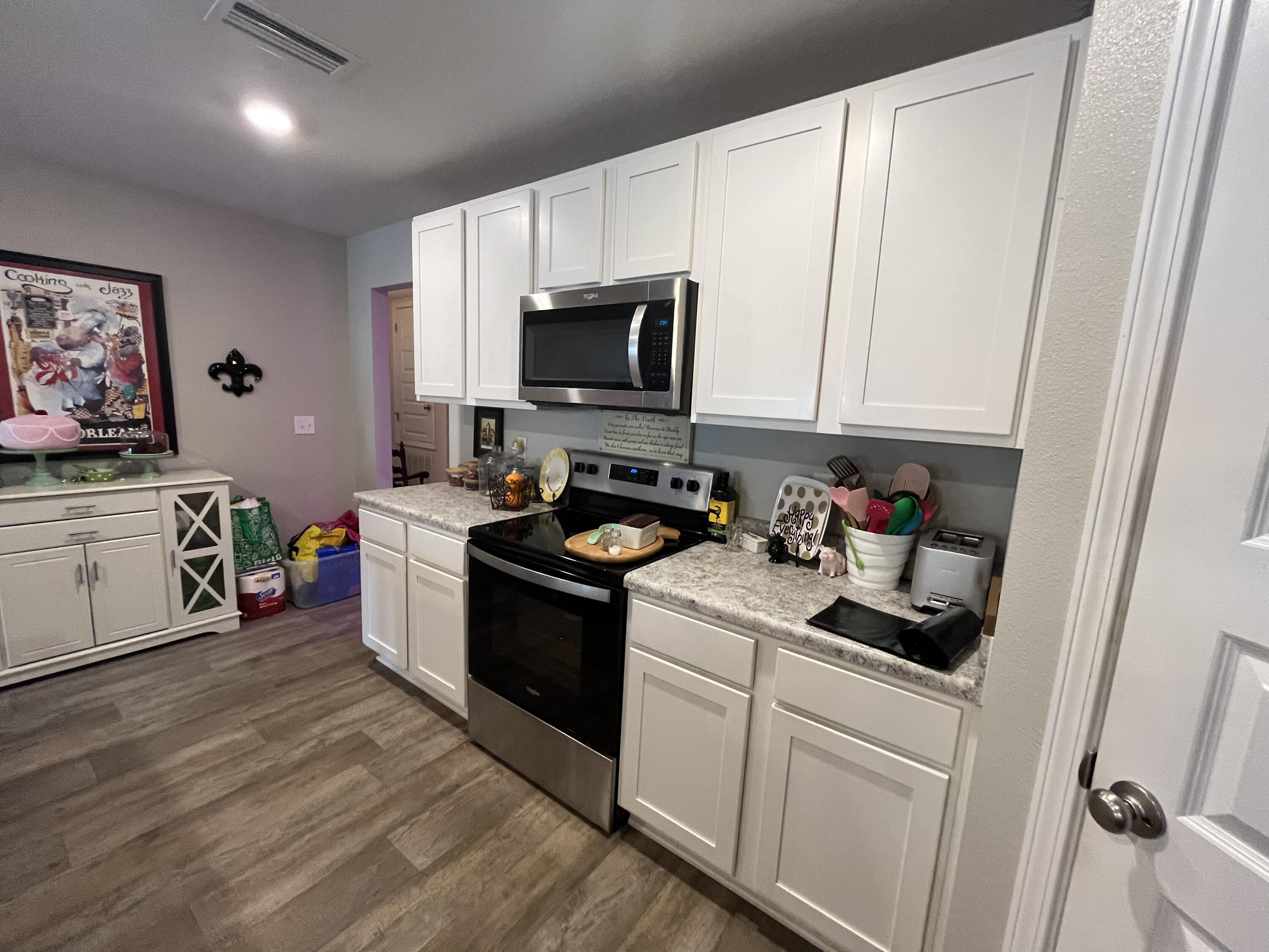 203 This Way Freeport, FL 32439 - Photo 22 of 29 a kitchen with granite countertop white cabinets sink and stainless steel appliances